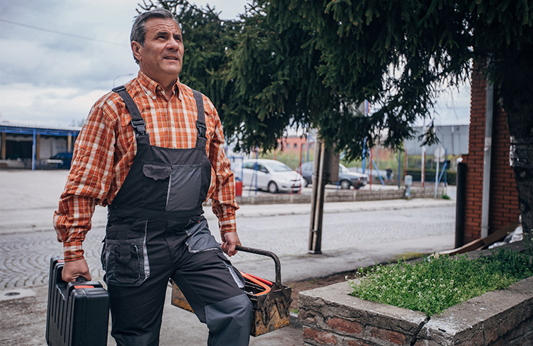 In a stock photo, a handyman arrives at a home in need of repairs
