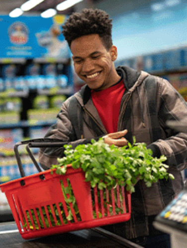 Happy man at grocery store checkout counter
