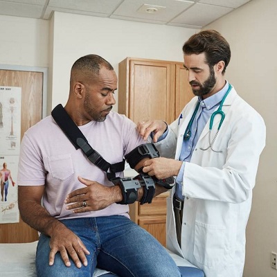 Man with an arm sling at a doctor appointment.