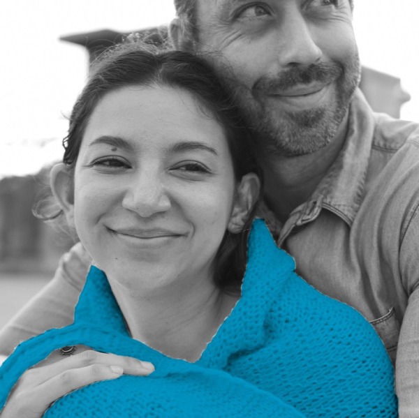 Two people hugging and smiling with a blue blanket