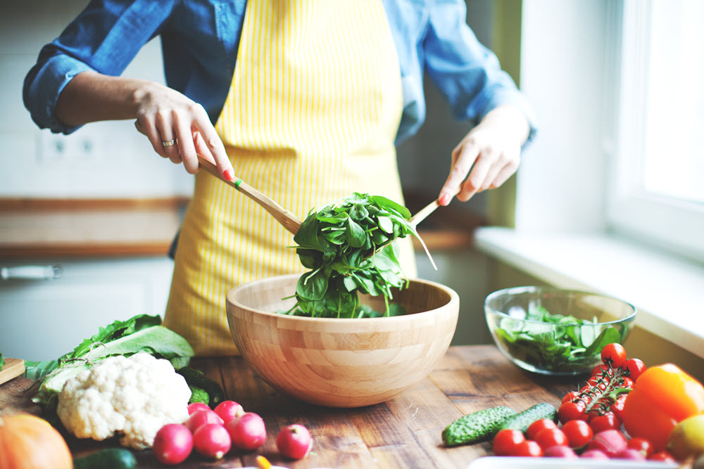 Woman in the kitchen making a nutritious salad