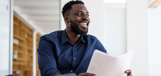 Man holding a piece of paper and smiling