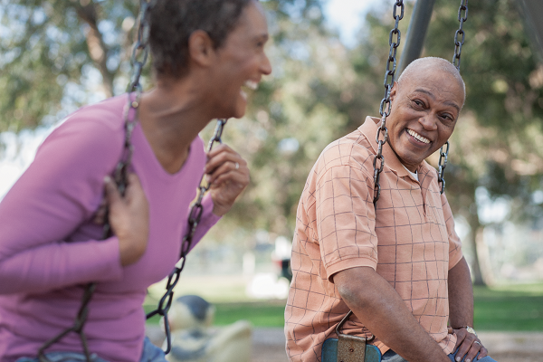 Older couple sitting on playground swings