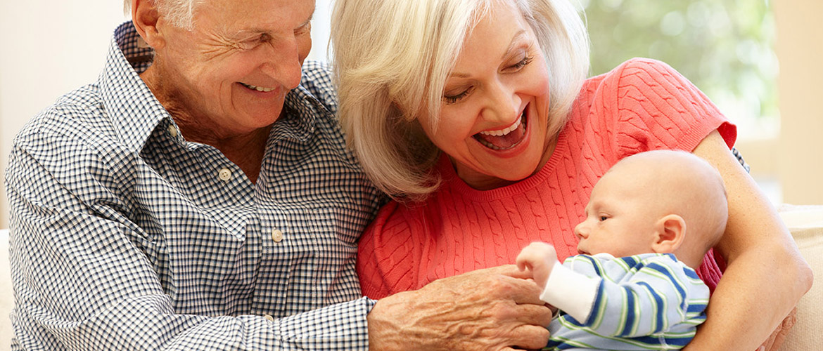 Older couple cuddles with a baby