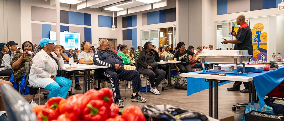 A chef performs a cooking demonstration for a large group