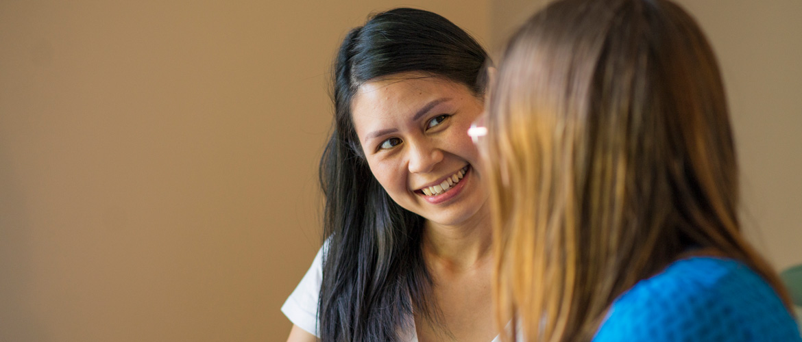 Smiling pregnant women talks with doula