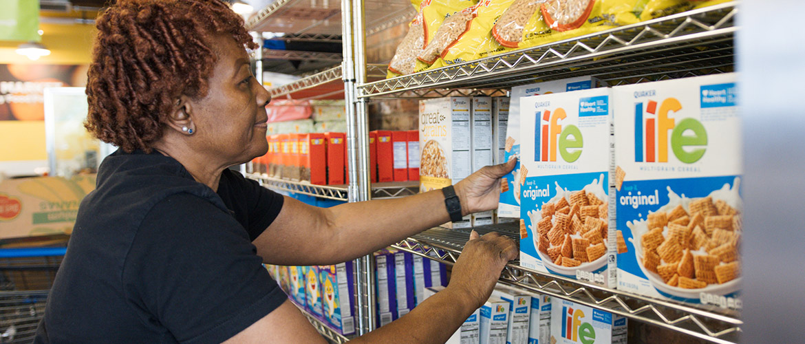 Woman stocks shelves with cereral boxes