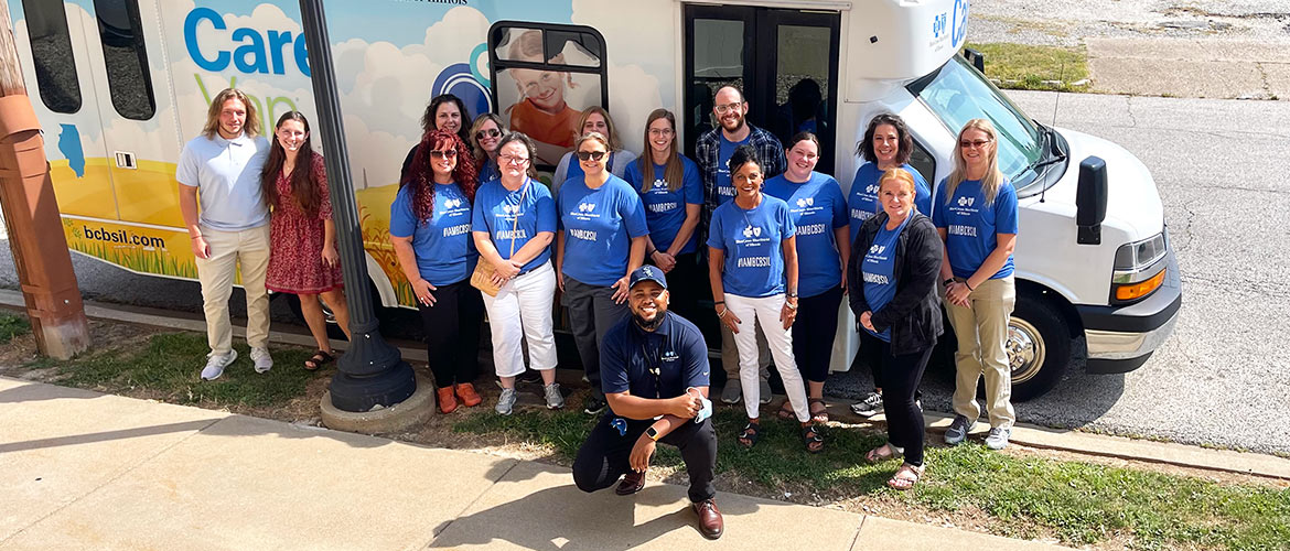 Volunteers and staff pose with the Blue Cross and Blue Shield of Illinois Care Van at an event with the National Kidney Foundation of Illinois