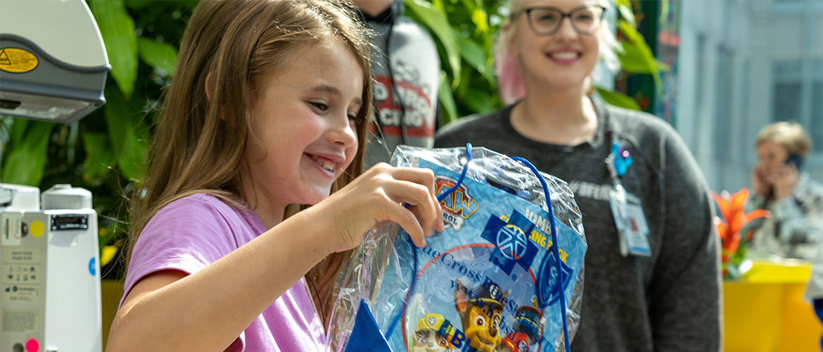 A patient at Lurie Children's Hospital opens a bag of toys during a visit from NASCAR and Blue Cross and Blue Shield of Illinois