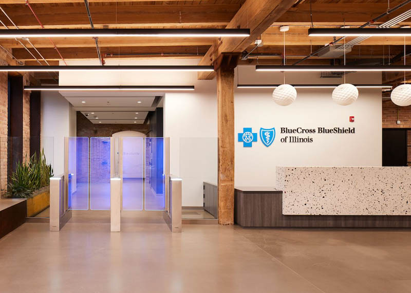 A reception area with Blue Cross and Blue Shield of Illinois logo, exposed brick and timber and moder decor. 
