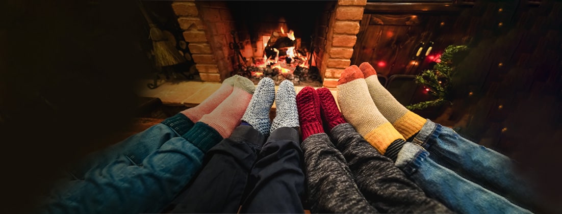 Feet in cozy socks in front of aa fireplace