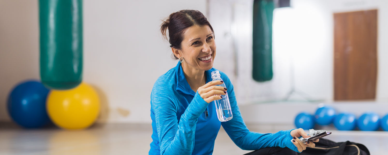 Woman in gym taking water break