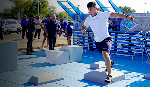 A young man demonstrates exercises at a new outdoor fitness court.