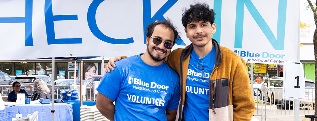 Dos voluntarios latinos posan para una foto en el Blue Door Neighborhood Center de South Lawndale.