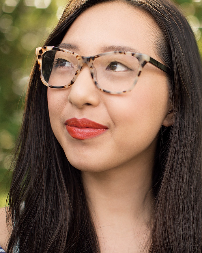 Mujer con gafas mira a lo lejos.