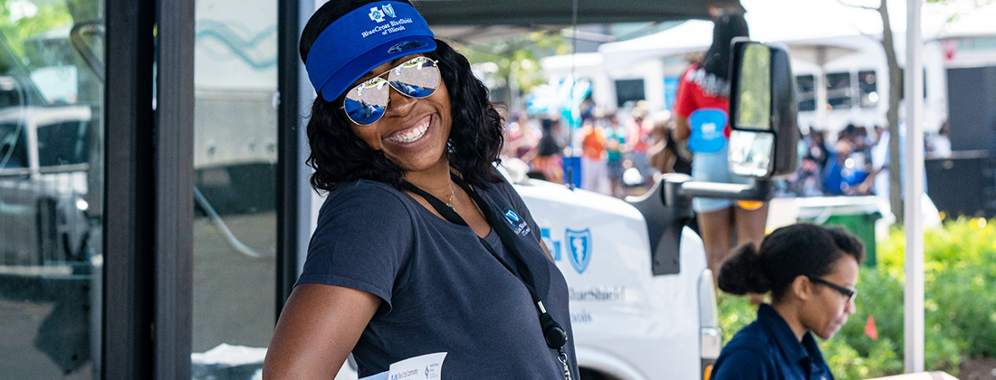BCBSIL employee poses at block party in front of Care Van®
