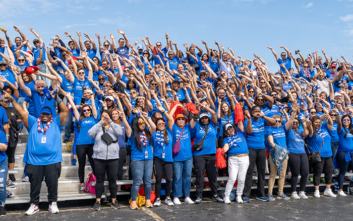 Bleachers full of BCBSIL employees posing together at event