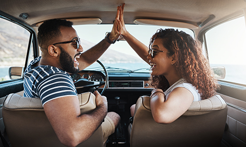 Couple high-fiving in car