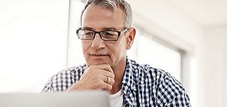 Hombre de mediana edad mirando hacia otro lado pensativo.